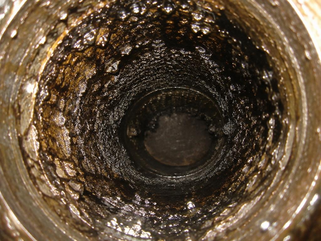 Soot buildup inside a stove pipe before cleaning